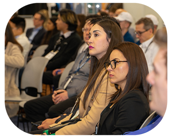  A group of people seated in chairs, engaged in discussion at a conference setting