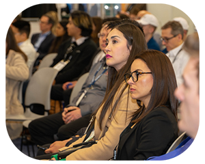  A group of people seated in chairs, engaged in discussion at a conference setting
