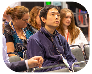  A group of people seated in chairs, engaged in discussion at a conference setting