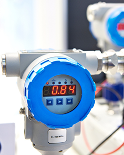 Close-up of a digital meter featuring a blue cap, displaying various measurement readings clearly