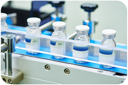 An automated machine is filling and sealing bottles of medicine in a production facility