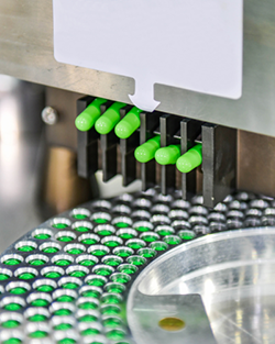 A machine producing green plastic bottles on a factory assembly line