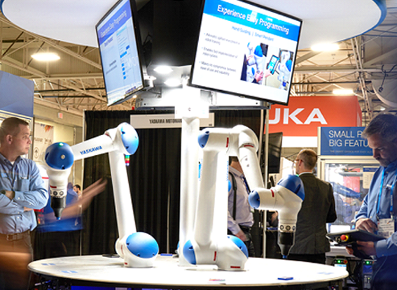 Attendees are looking robotic arms displaying on the expo hall